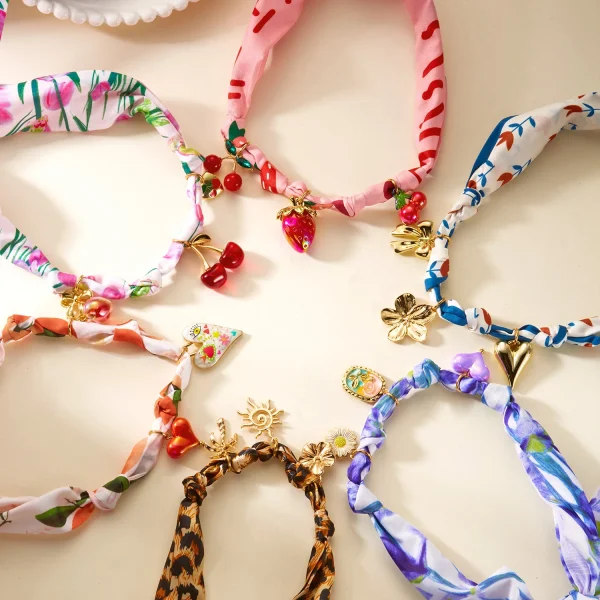 عقد نسائي بتعليقة على شكل كرز وفراولة وقلب مع فيونكة، مزين بشريط ملوّن