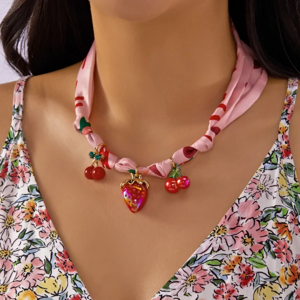 عقد نسائي بتعليقة على شكل كرز وفراولة وقلب مع فيونكة، مزين بشريط ملوّن