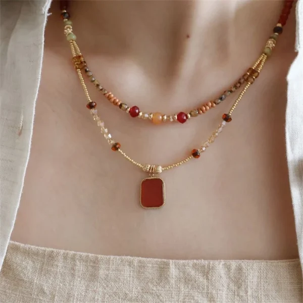 عقد نسائي بخرز زجاجي ملون مع تعليقة على شكل قلب، مزين بحجر بني عتيق