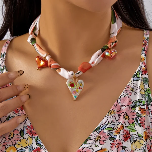 عقد نسائي بتعليقة على شكل كرز وفراولة وقلب مع فيونكة، مزين بشريط ملوّن